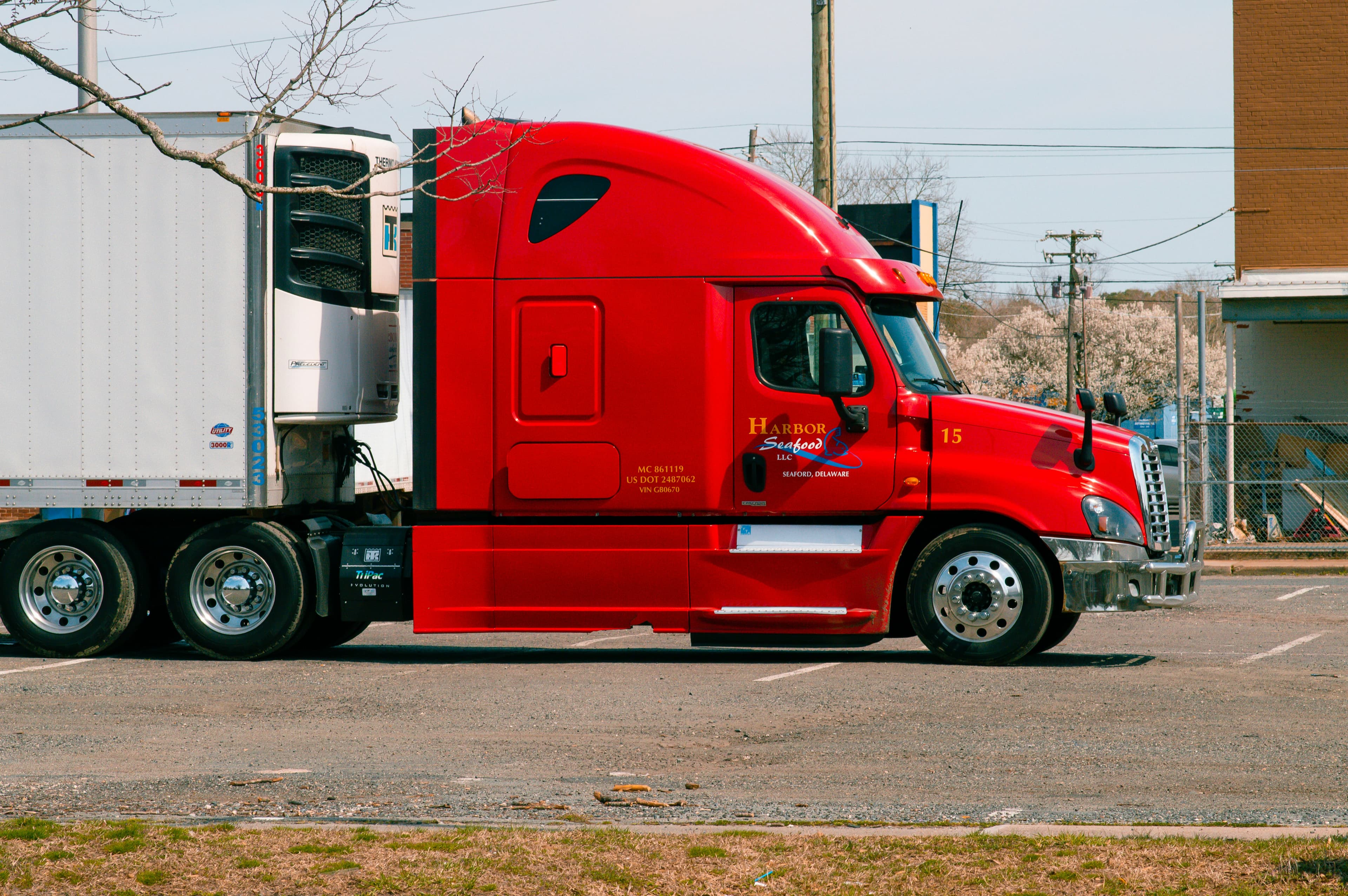 Red sleeper tractor hooked to a refrigerated trailer with its reefer unit visible