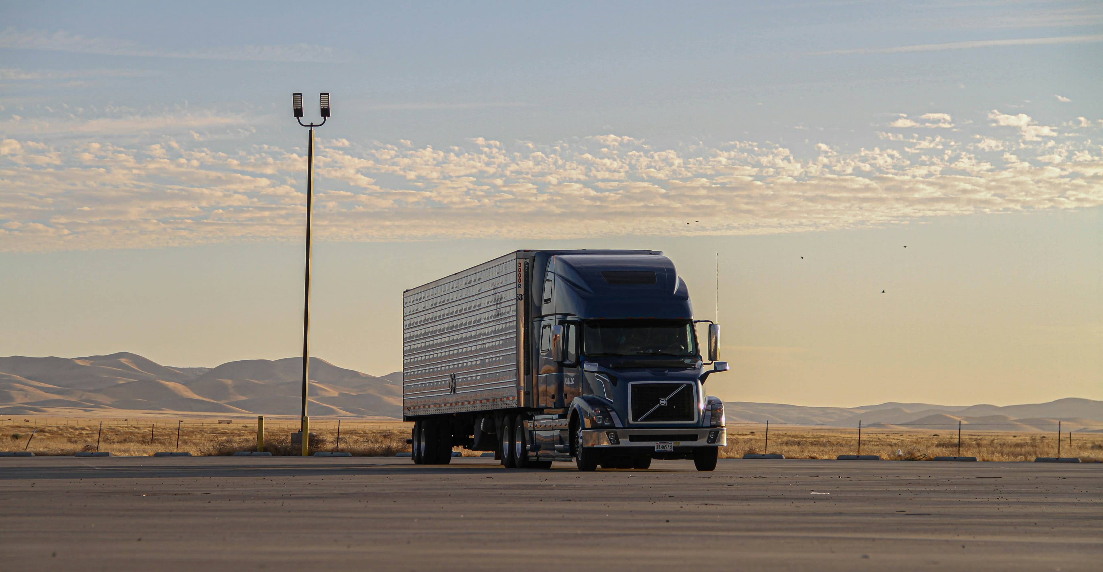 Tractor-trailer on a desert highway at golden hour
