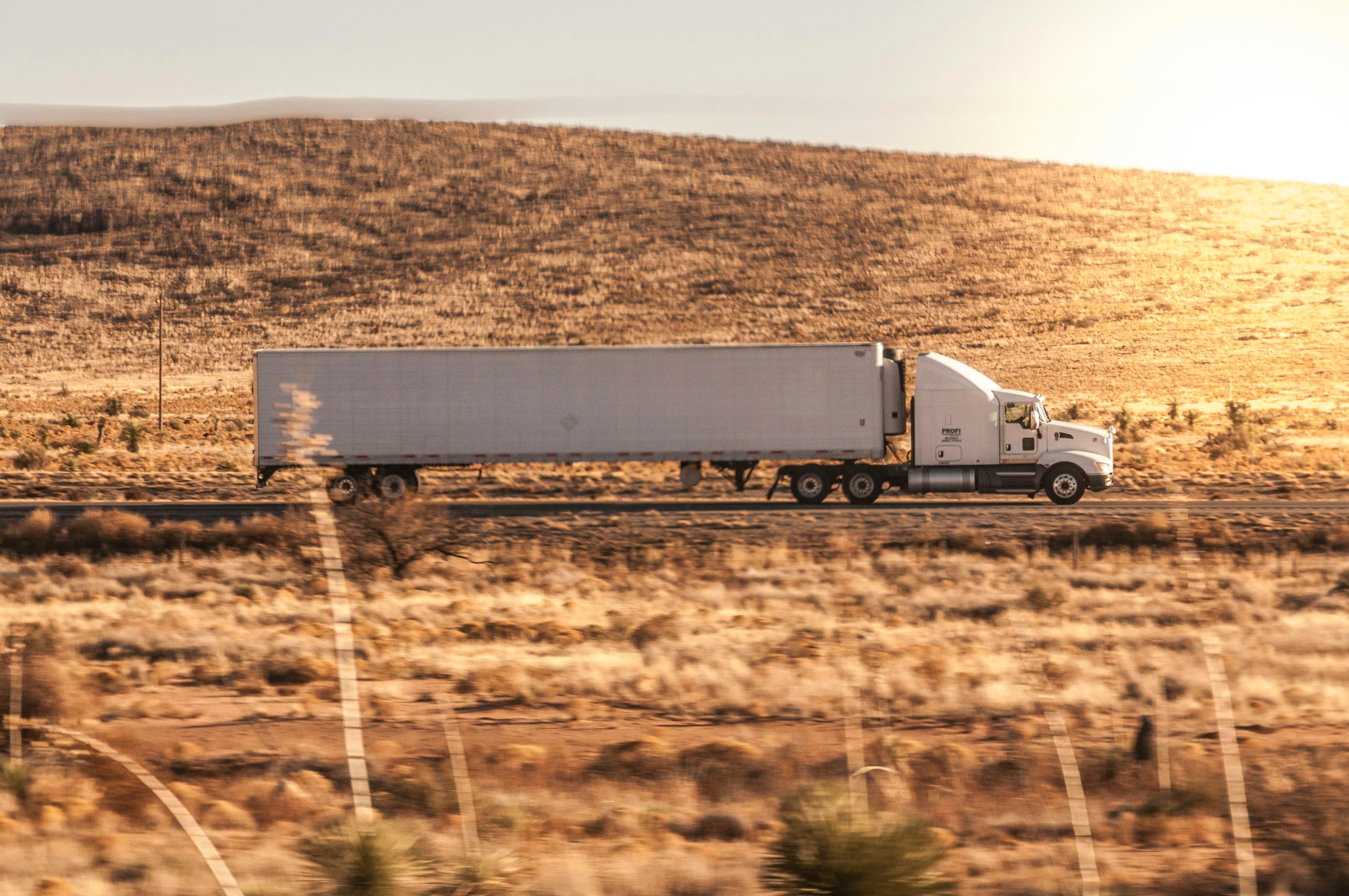 Tractor-trailer crossing dry golden rangeland