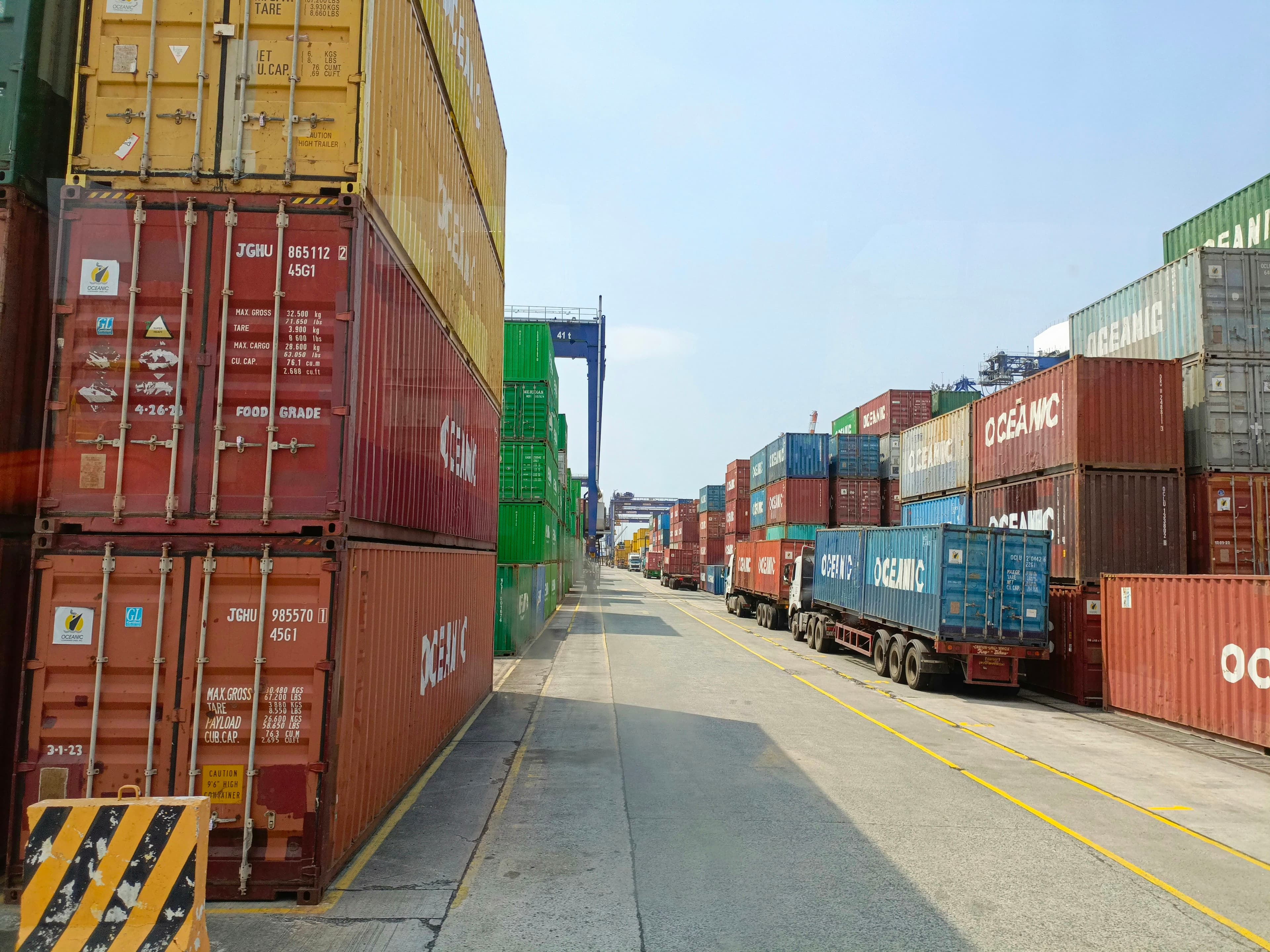 Container trucks lined up between stacks at a marine terminal