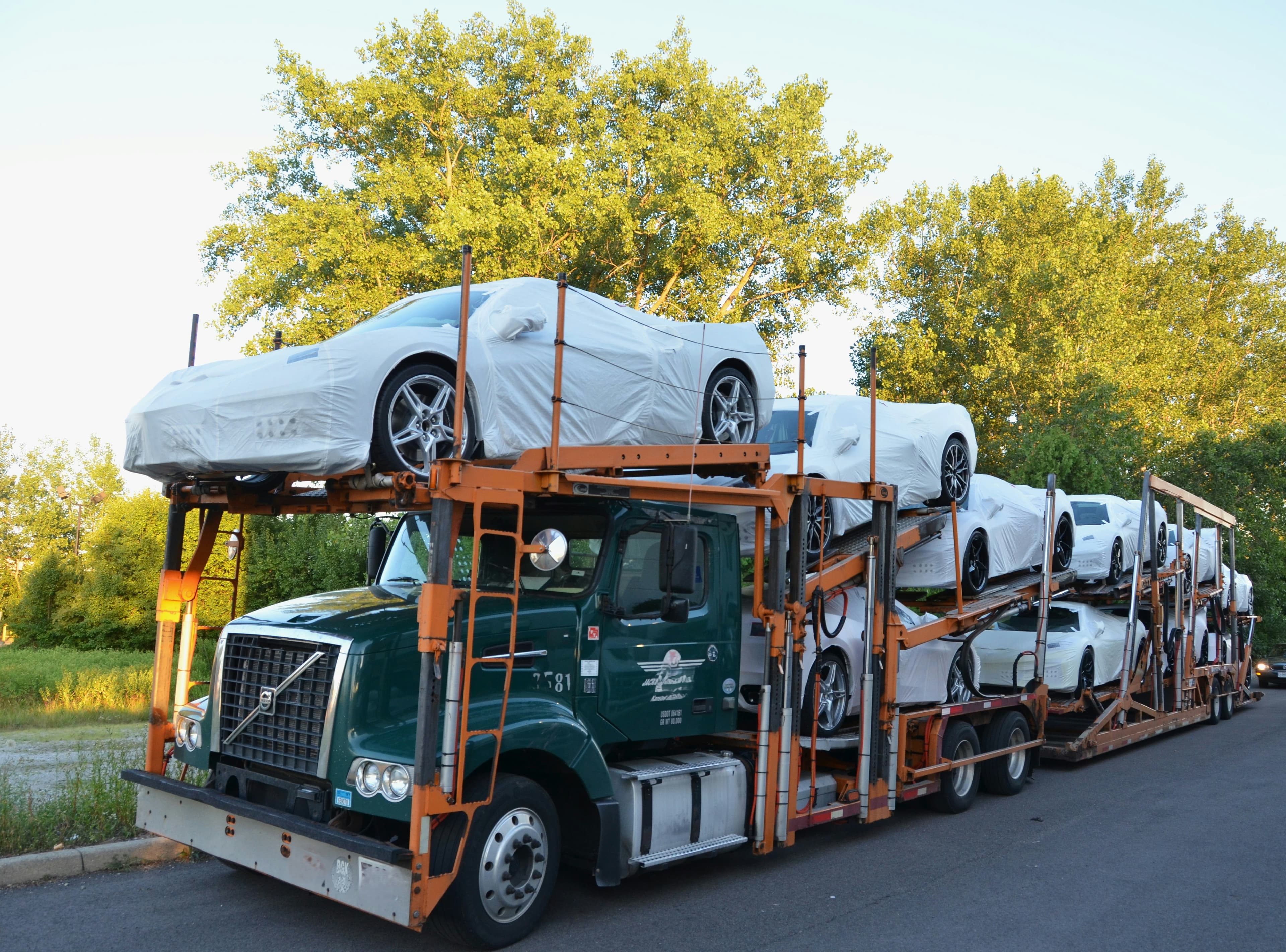 Car hauler loaded with covered new vehicles