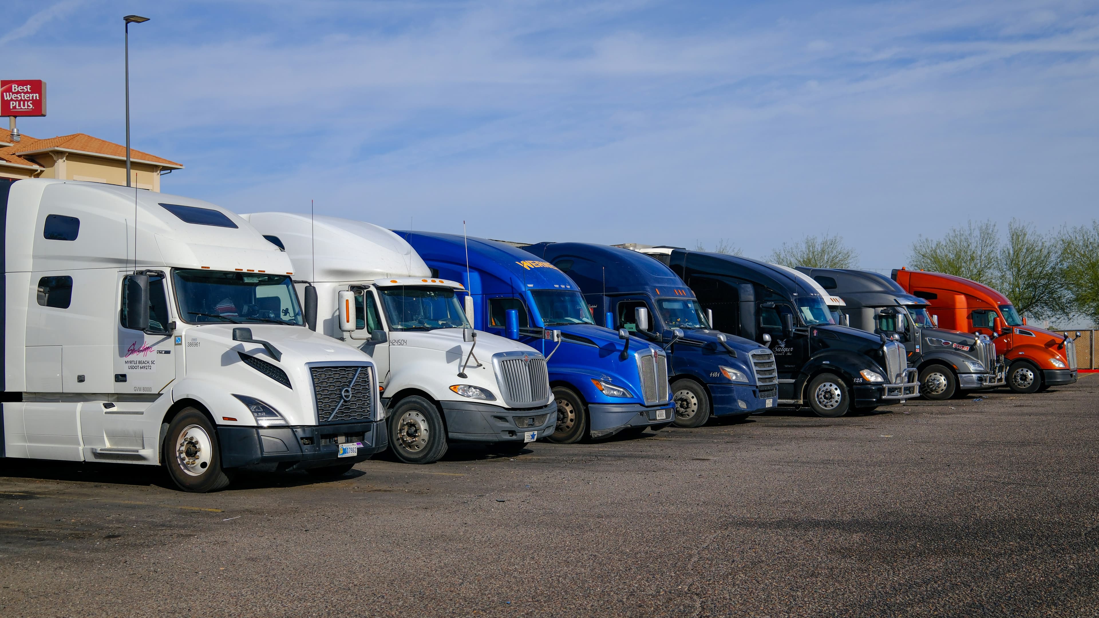 Row of sleeper tractors parked in a fleet lot