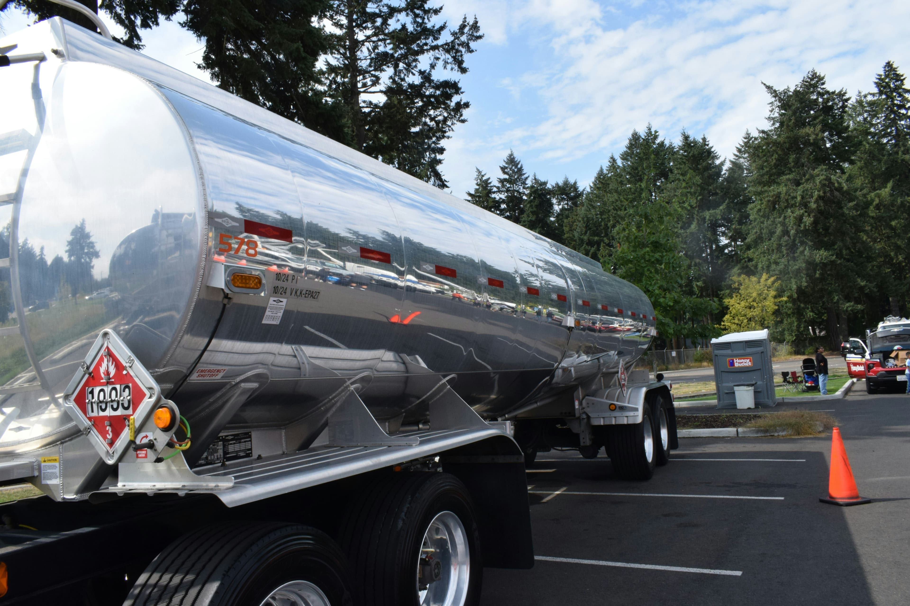 Polished tank trailer with a hazmat placard on the rear