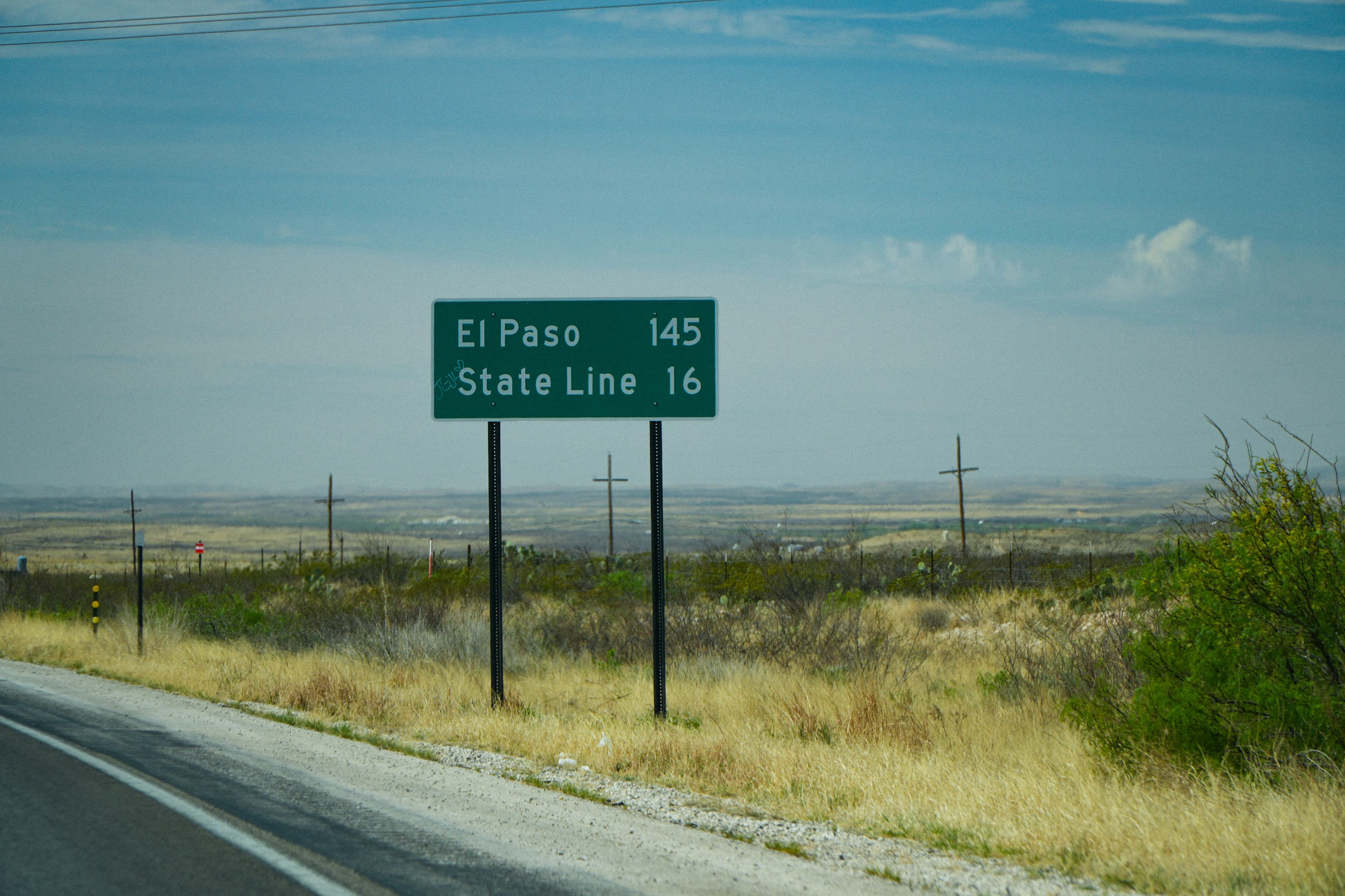 Highway sign for El Paso and the state line in the West Texas desert